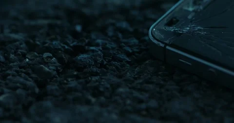 Crashed smartphone rests on the road's asphalt. Stock Footage 261985675