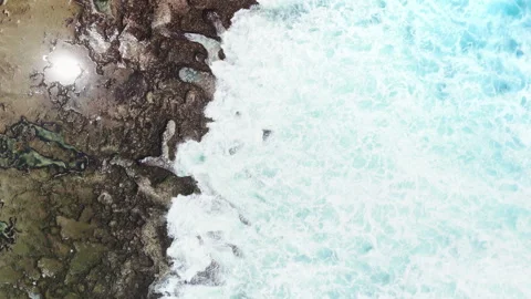 Crashing ocean waves and foam on the reef rocks, top down drone view Stock Footage 345366790