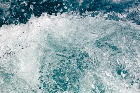 Crashing wave creates frothy, dynamic motion in deep blue water Stock Photos