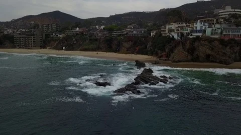 Crashing waves on a beach front town Видео 91592633