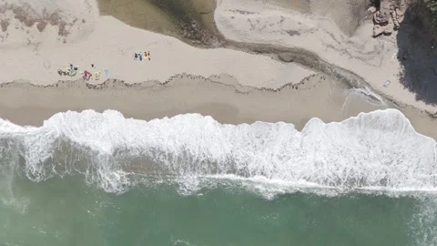 Crashing waves on the beach with sunbathers on the sand Stock Footage 288729492