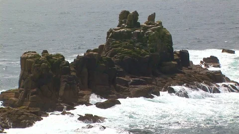 Crashing waves breaking on Armed Knight rock formations in Cornwall, England. Stock Footage 101490478