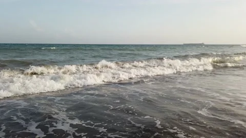 Crashing waves on a dark sand beach 库存影片 164055322