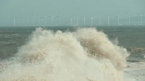 Crashing Waves In Front Of Wind Turbines. 库存影片 136667787