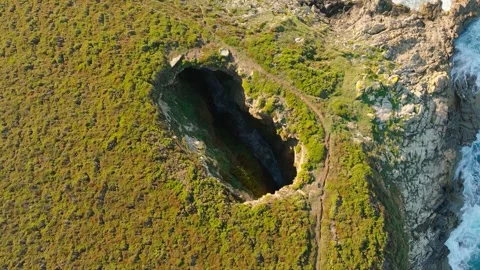 Crashing Waves Inside The Hole Of Monte Furado - aerial descend Stock Footage 252833800