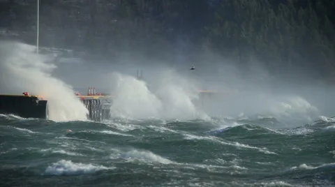 Crashing waves on pier, sea spray, hurricane gale force wind storm, bird flying Stock Footage