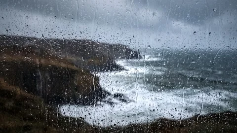 Crashing waves on a rocky coast through frosted rainy glass. 4K Video stock 343244065