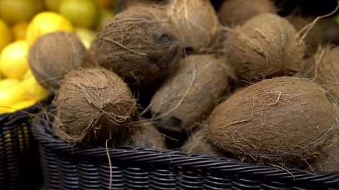 A crate filled with whole coconuts rests on a shop counter Stock Footage 323232803