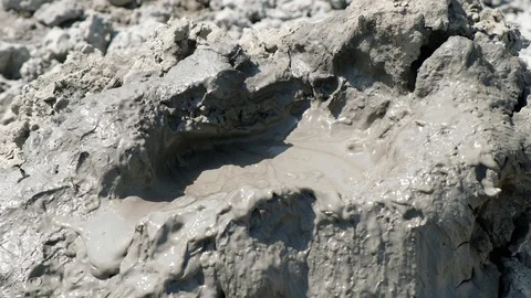 Crater of mud volcano bursting bubbles with natural gas. Stock Footage 104993617