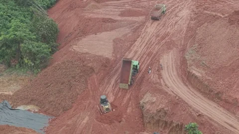 A crawler bulldozer is leveling the fill soil unloaded from a truck for roa.. Stock Footage 334923991