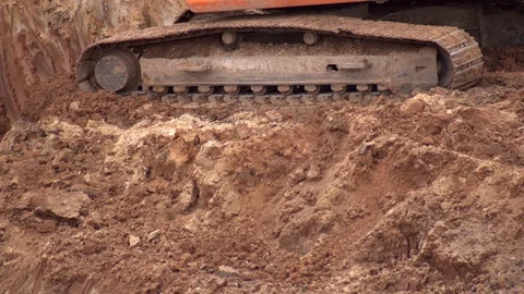 Crawler excavator digging the earth with a bucket at a construction site, close Vídeo Stock 129745616
