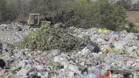 Crawler excavator driver scooping junk on dump site on sunny day. Stock Footage 81657770