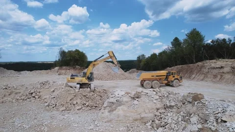 Crawler excavator loading dump truck with gravel in open pit. Quarry and mining Video stock 213668399
