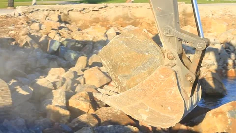 A crawler excavator picks up the rocks and fills the sea. Hydraulic digger  Stock Footage 287776904