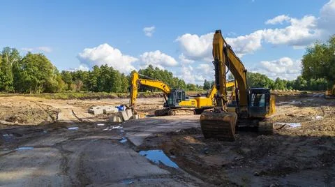 Crawler excavators level the ground at a construction site for a building Stock Photos