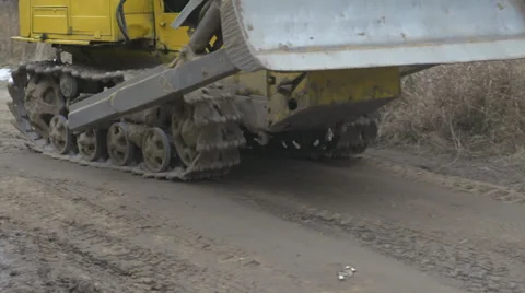 Crawler tractor with a bucket rides on clay Stock Footage 34272148