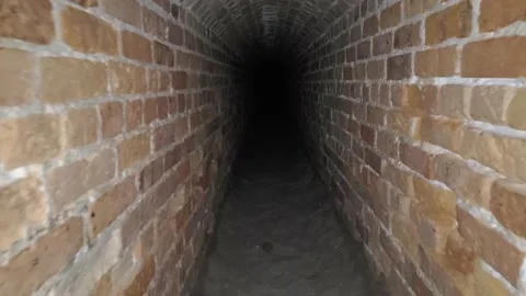 Crawling and dragging backpack through abandoned tunnel in an old ruin. Stock Footage 219372728
