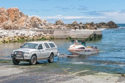 Crayfish boat being pulled onto trailer at Kleinmond harbor. Stock Photos