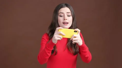 Crazy addicted lady play game device fist up isolated brown color background Stock Footage 189365533