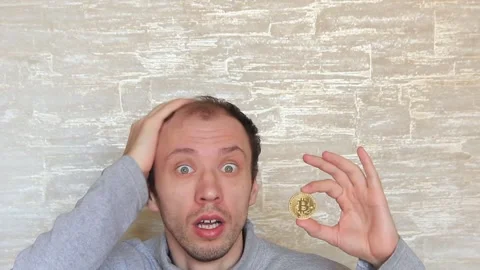 Crazy, agitated guy with a bitcoin coin in his hands. Stock Footage 152556220