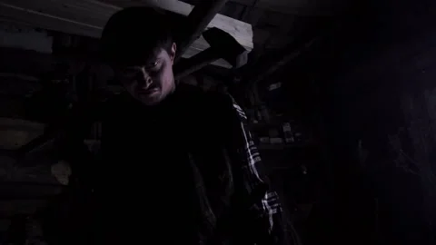 Crazy angry drunk man with a sledgehammer looking at the camera in an old house Video stock 135654820