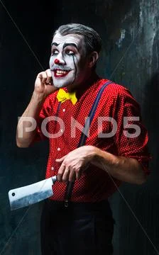 The crazy clown holding a knife on dack. Halloween concept Stock Photos