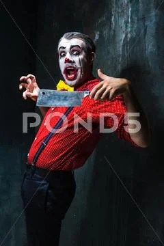 The crazy clown holding a knife on dack. Halloween concept Stock Photos