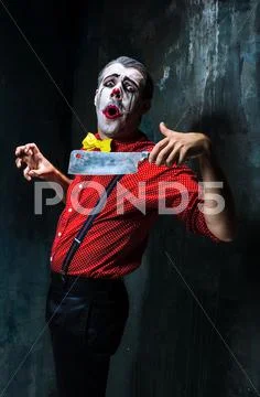 The crazy clown holding a knife on dack. Halloween concept Stock Photos