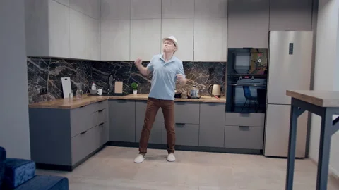 Crazy dance of a man in a hat on a kitchen background Stock Footage 166542307