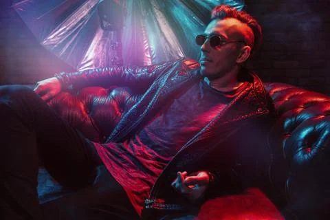 A crazy disco man is lying on the sofa. Party, disco. Colorful light. Stock Photos