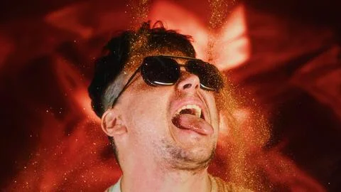 Crazy fun man sprinkles himself with sparkle particles. Fun photo funny face Stock Photos