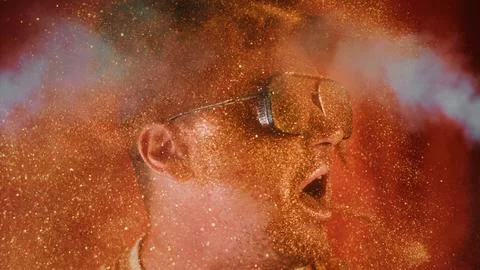 Crazy fun positive face man in gold glitter and smoke mist.Comical photo shake Stock Photos