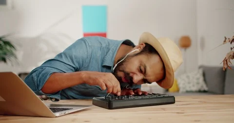 Crazy funny Hispanic man in hat writing creative music using DJ piano pad at Stock Footage 120744349