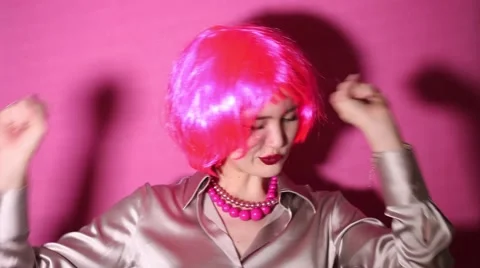 Crazy girl dancing while wearing pink wig and swearing Stock Footage 64839907
