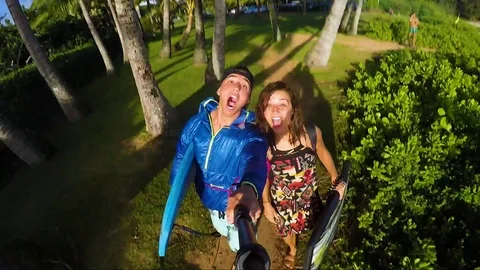 Crazy Go Pro transition of a couple running into the ocean with boogie boards la Stock Footage 99376596