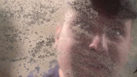 Crazy guy cleans and peers through dirty glass Stock Footage 133231986