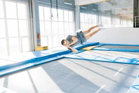 Crazy guy trying to sleep while jumping on the trampoline Stock Photos