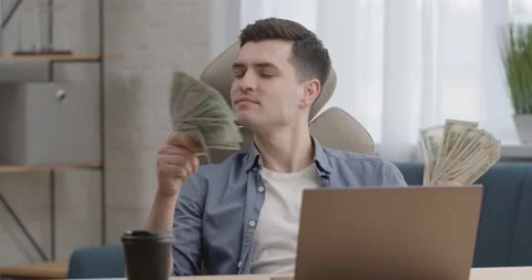 Crazy Happy Man Programmer holding Dollars in hands enjoying of Smelling Stock Footage 150558162