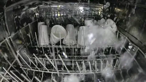 Crazy idea is to wash plastic glasses in the dishwasher. Stock Footage 158326145
