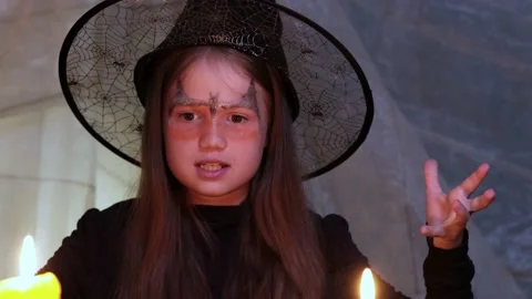 Crazy little witch reads a spell at Halloween night by candlelight Stock Footage 211820146