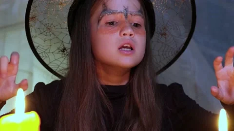Crazy little witch reads a spell at Halloween night by candlelight close up Stock Footage 211820205