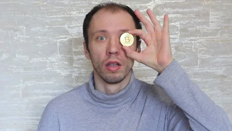 Crazy looking guy with a bitcoin coin in his hands. Stock Footage 150709953