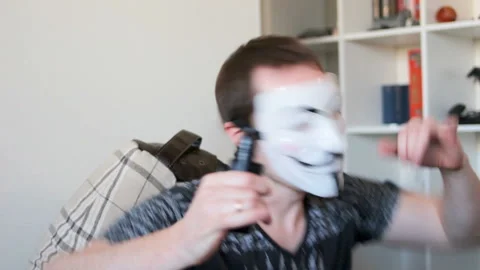 A crazy man with an anonymous v for vendetta mask dancing Stock Footage 91361962