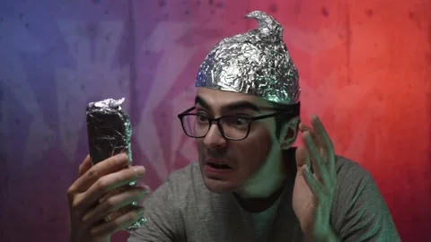 Crazy Men With a Tin Foil Hat Video Calling Using a Smartphone Stock Footage 136132311