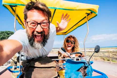 Crazy people happy couple have fun on vacation driving together a bike - tour Stock Photos