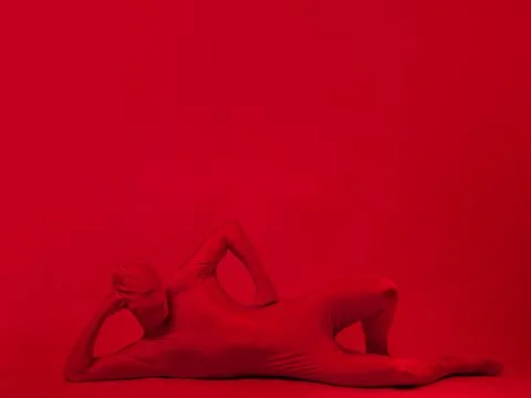Crazy red man on a red background. figure in a leotard covering the whole body Stock Photos