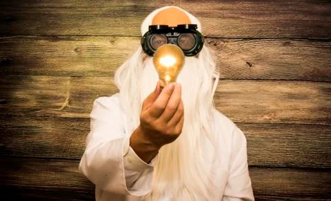 Crazy scientist elderly man holding an inexplicably lit bulb with some strang Stock Photos