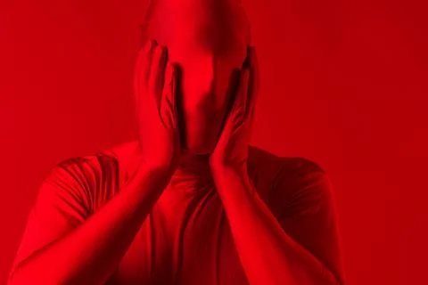 Crazy screaming red man on a red background. figure in a leotard Stock Photos