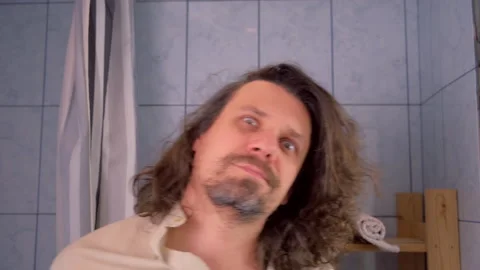 Crazy staggering drugged bearded man with long hair has hangover in bathroom. Stock Footage 312099155