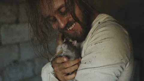 Crazy Terrible Maniac In Basement With Window Playing With Rat Video stock 116095499